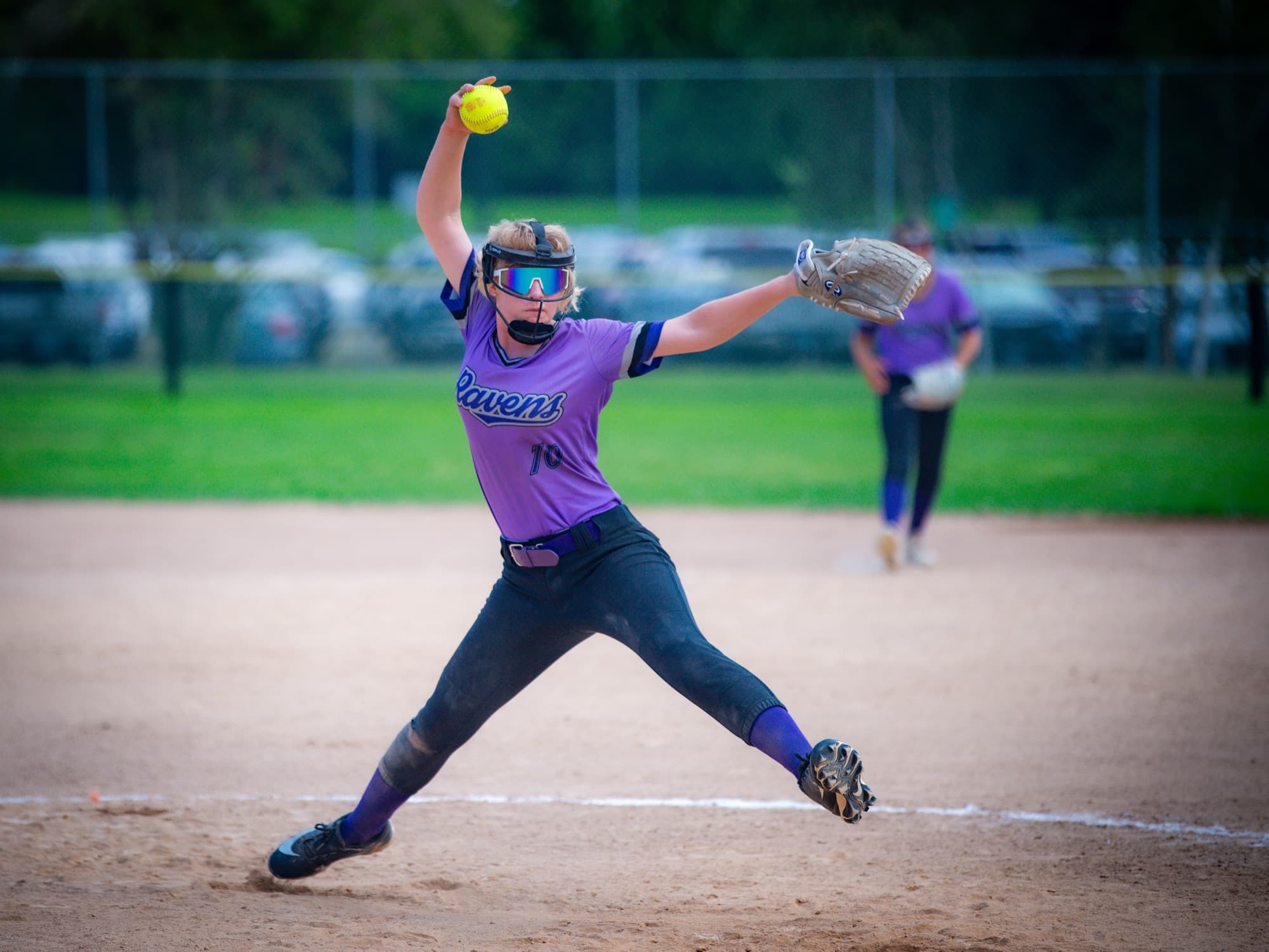 A Ravens softball pitcher mid-windup